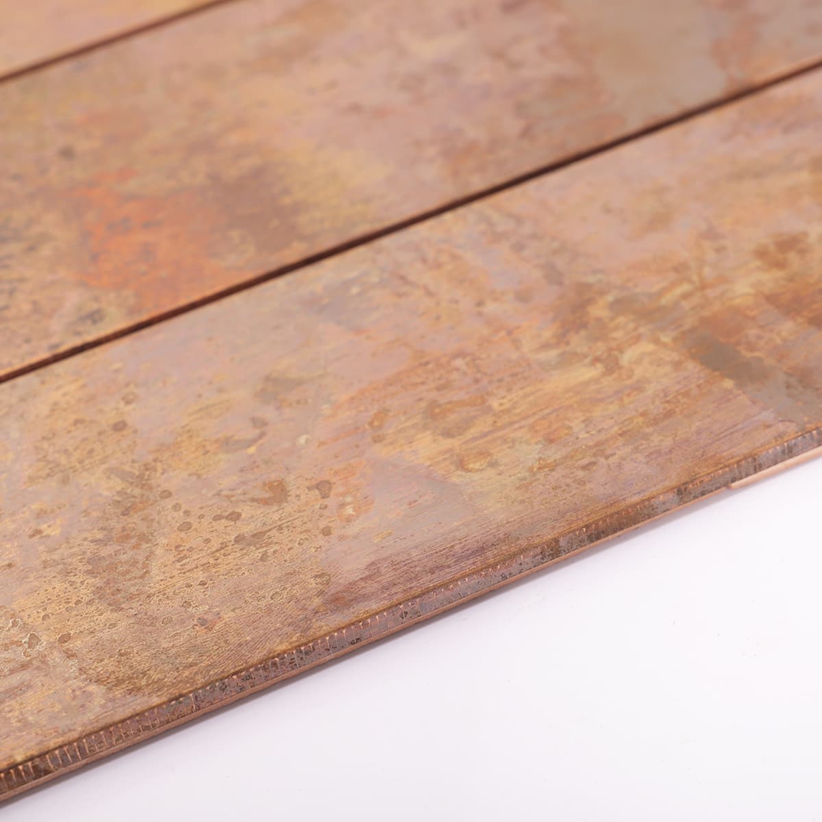 Edge detail of copper mosaic tile with matte sheen
