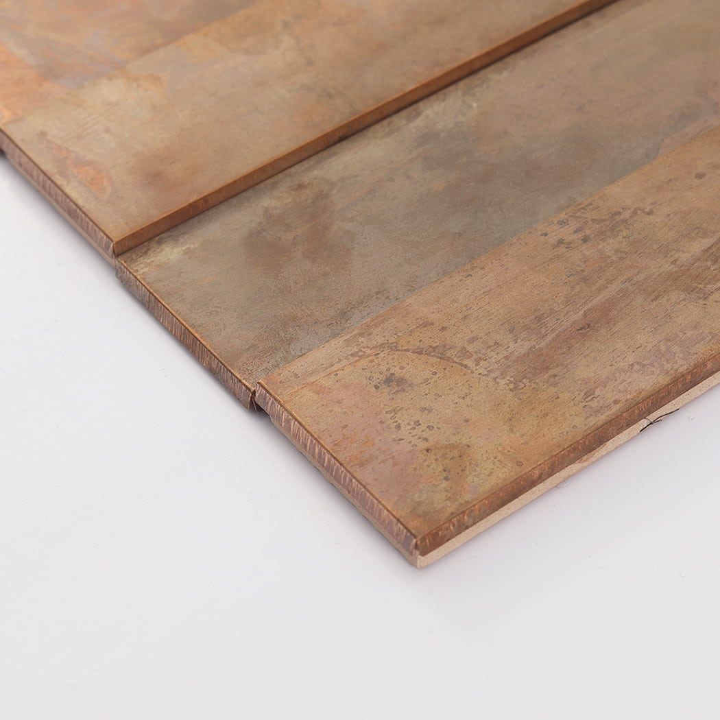 Side angle view of a copper mosaic tile highlighting its slim profile and layered structure.
