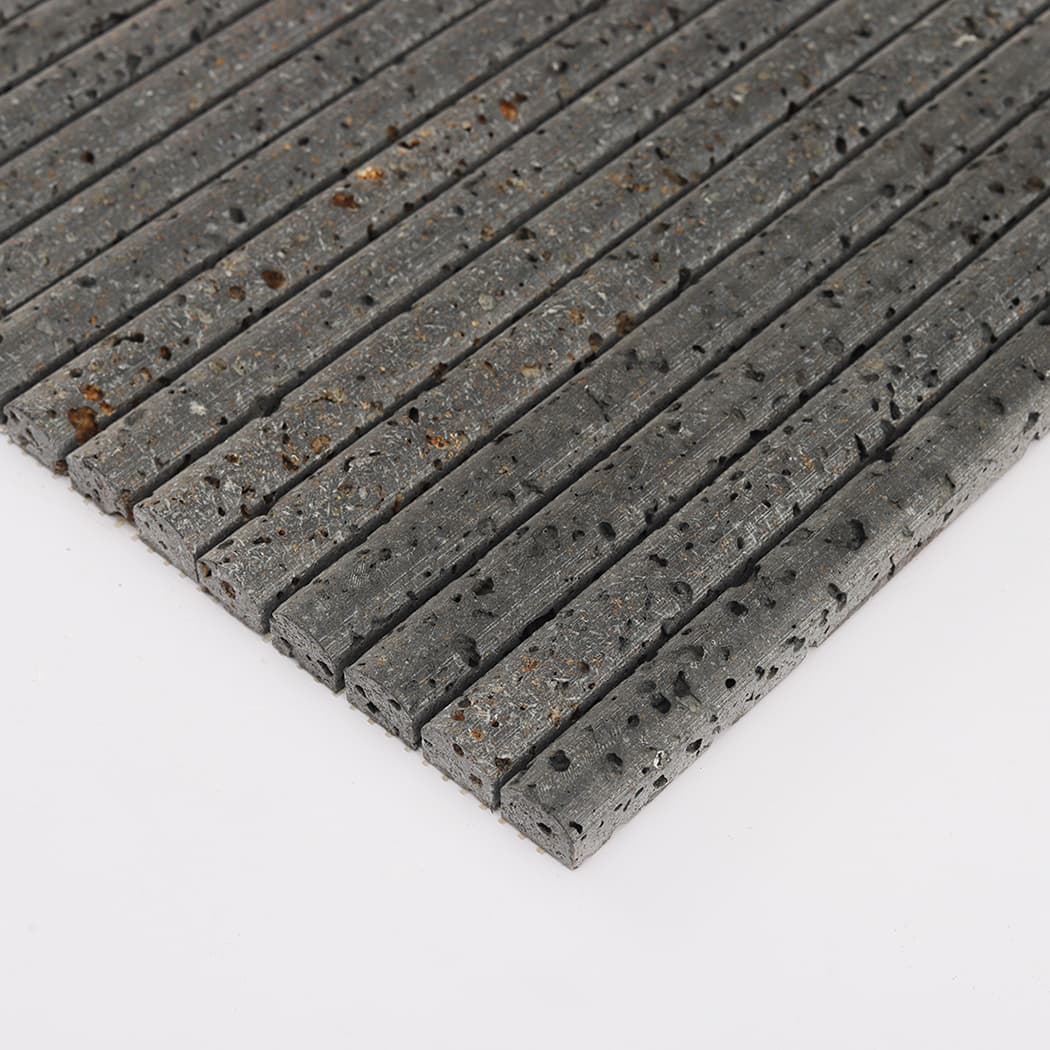 Angled shot highlighting the thickness and side profile of black lava stone pencil mosaic strips.