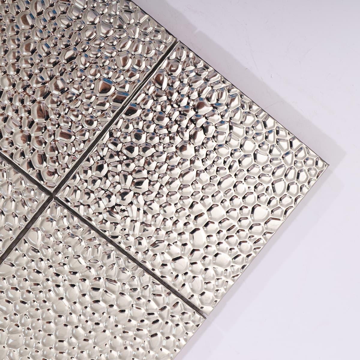 Close-up of silver hammered mosaic tile corner