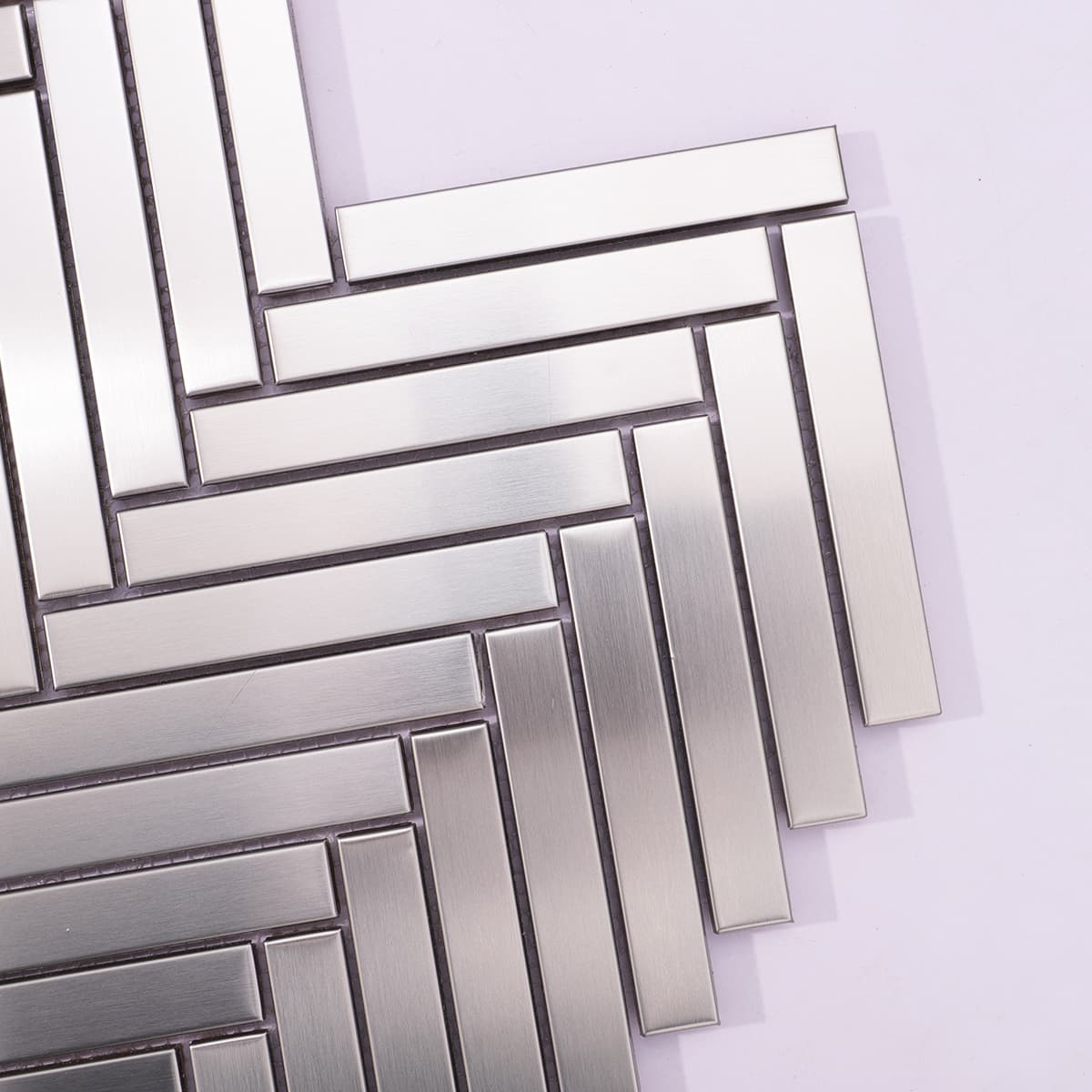 Corner detail of brushed stainless steel herringbone tile