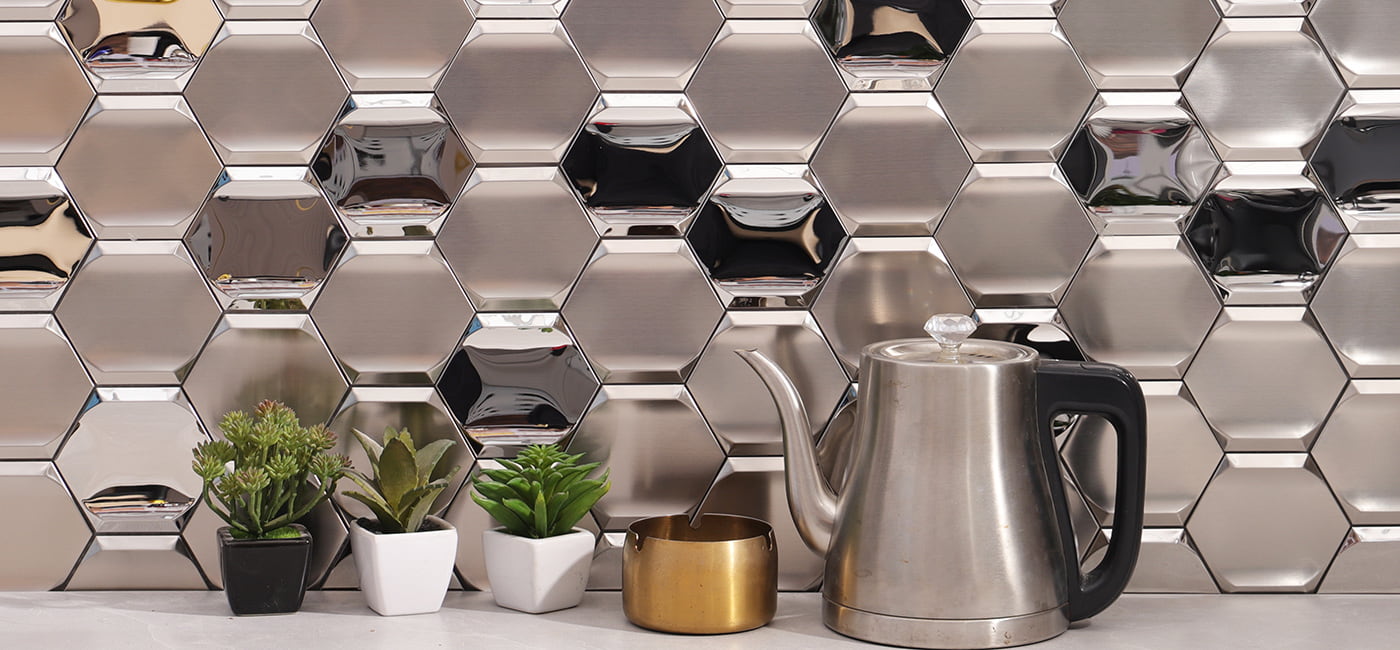 Wide view of silver hexagon metal mosaic backsplash with kettle and potted succulents