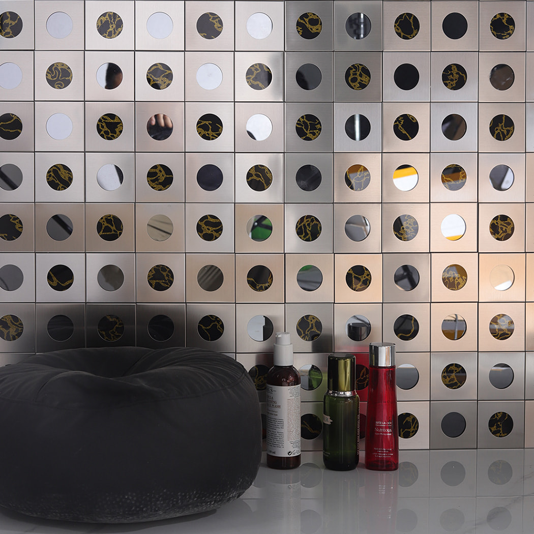 Silver mosaic wall with circular mirrors and gold pattern used as wall decor.