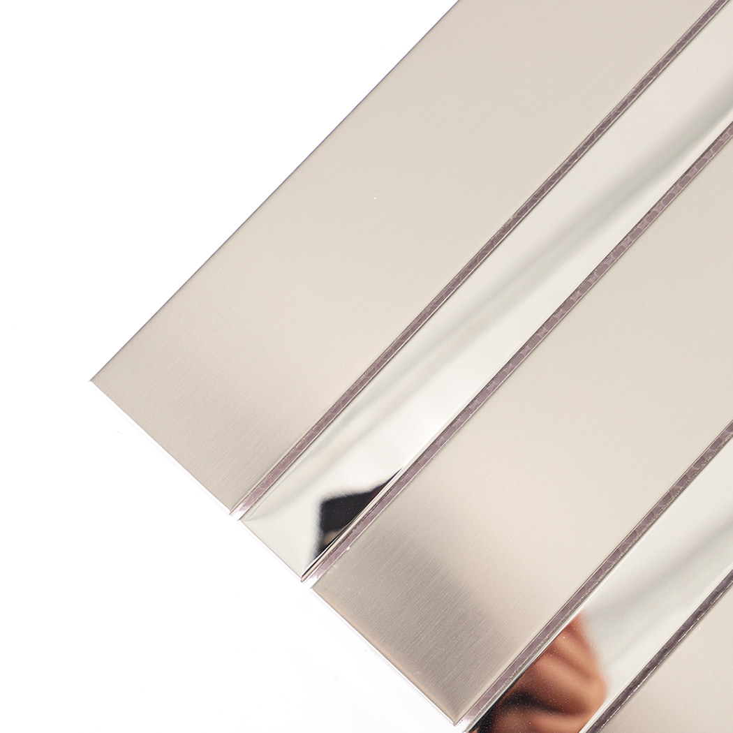 Close-up view showing brushed and mirror surfaces of silver stainless steel tile
