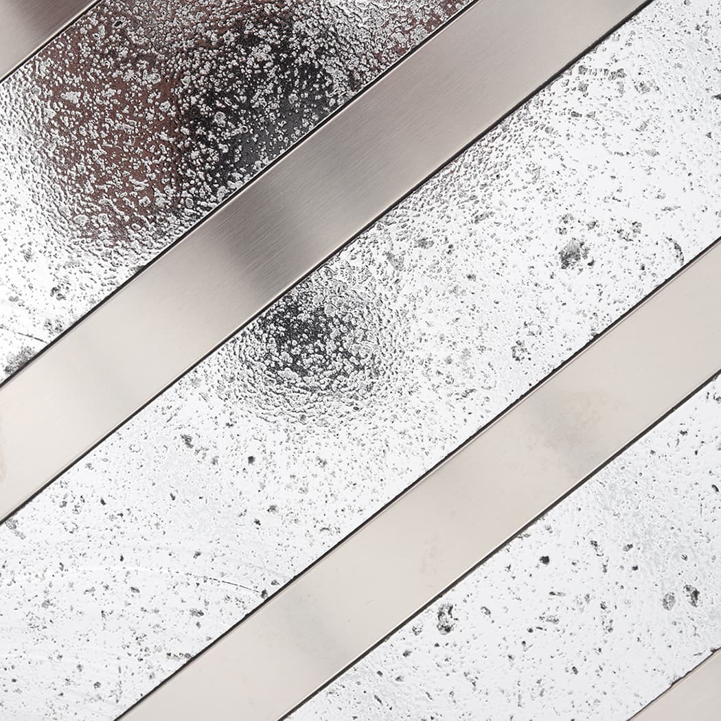 Silver speckled electroplated stone surface beside brushed stainless steel strips