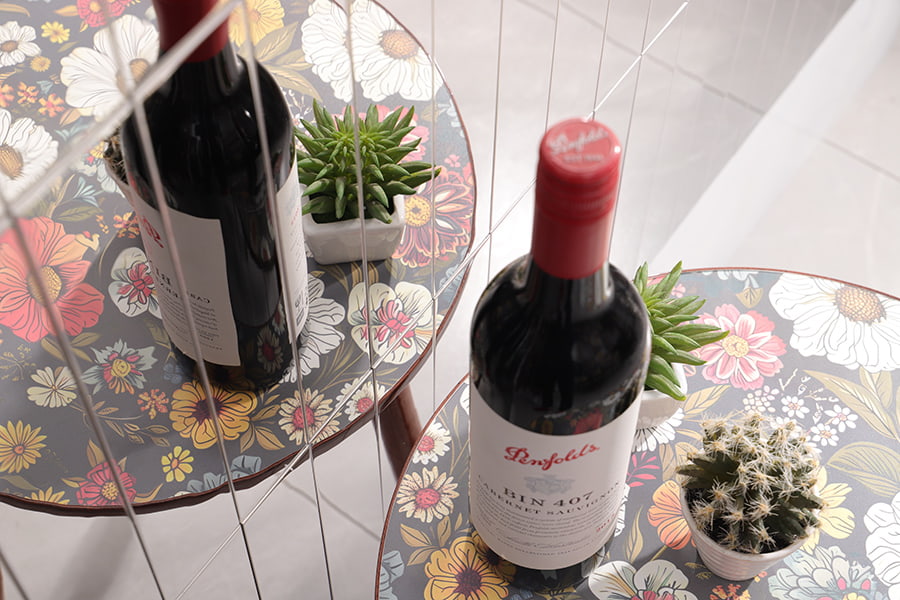 Top view of wine bottle and cactus reflected in silver tile backsplash