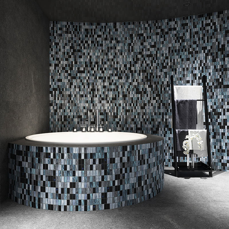 Dark mosaic of small rectangular tiles around round bathtub and wall