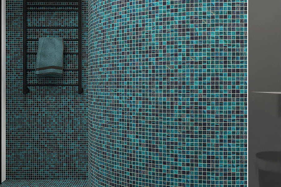Small square blue-green mosaic tiles on curved shower wall