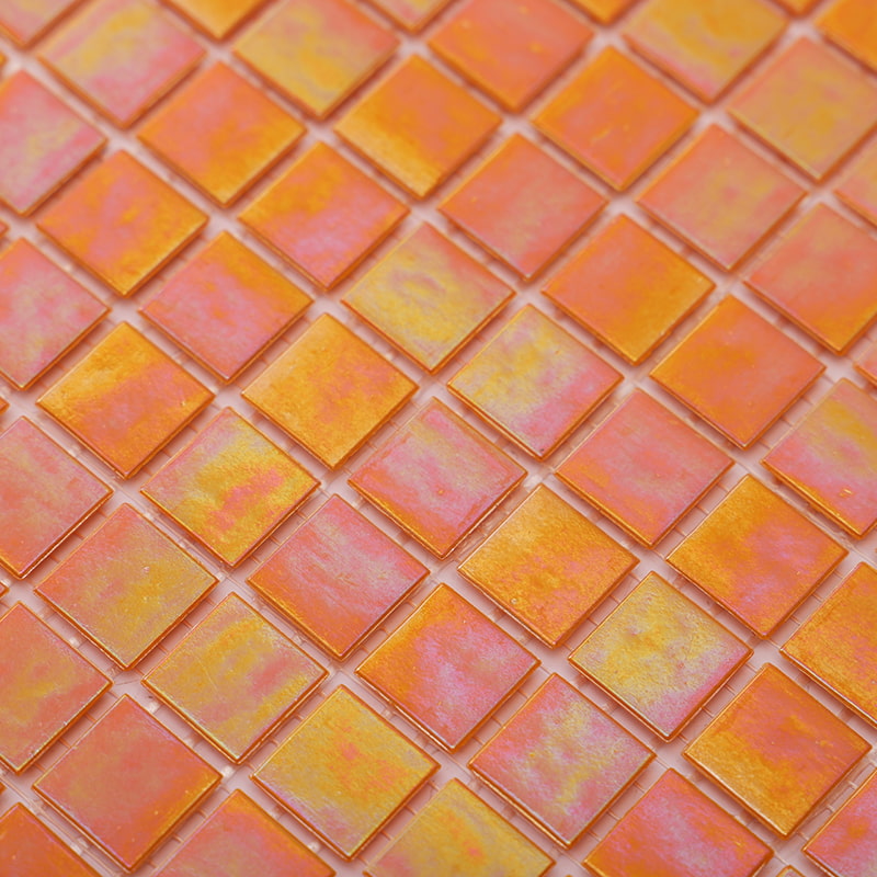 Close-up of iridescent orange glass pool mosaic tiles showing warm gradients and shimmering light