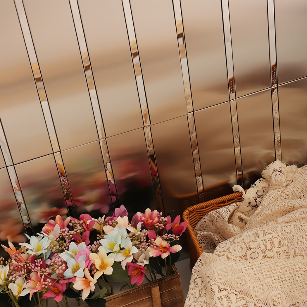 Close view of stainless steel mirror strip mosaic wall with decorative flowers.