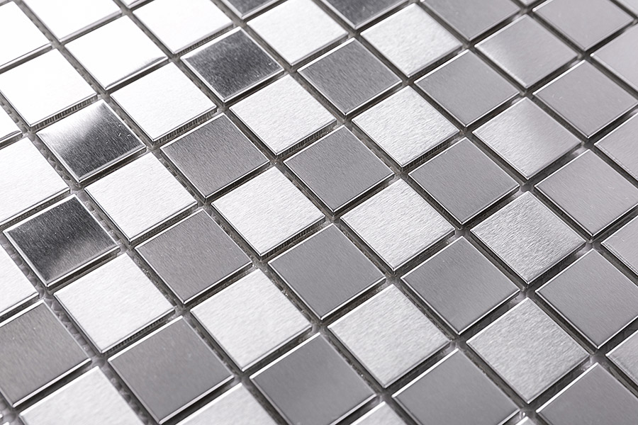 Detailed shot of square stainless steel mosaic tiles in a mix of silver and grey tones.