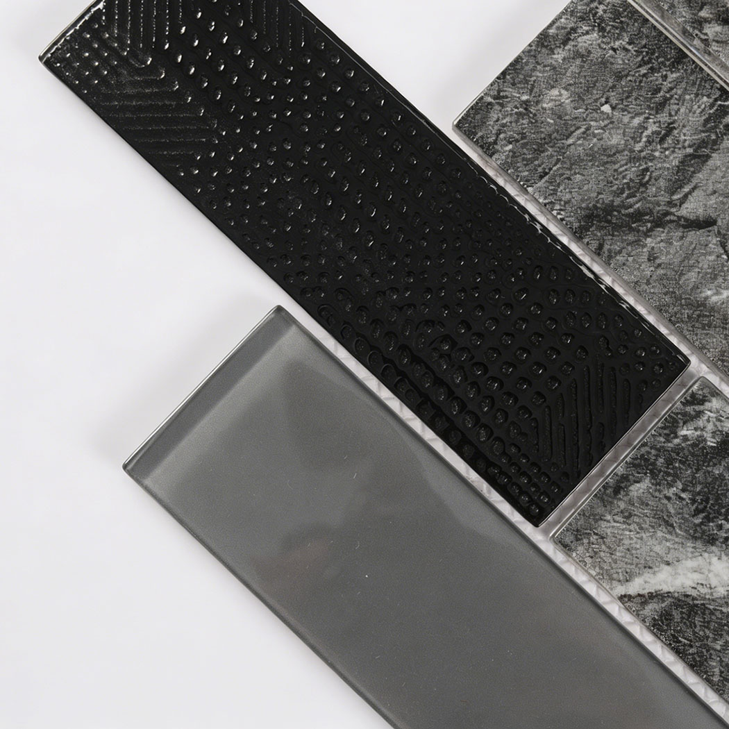 Close up of textured black glass and gray glass subway mosaic tiles