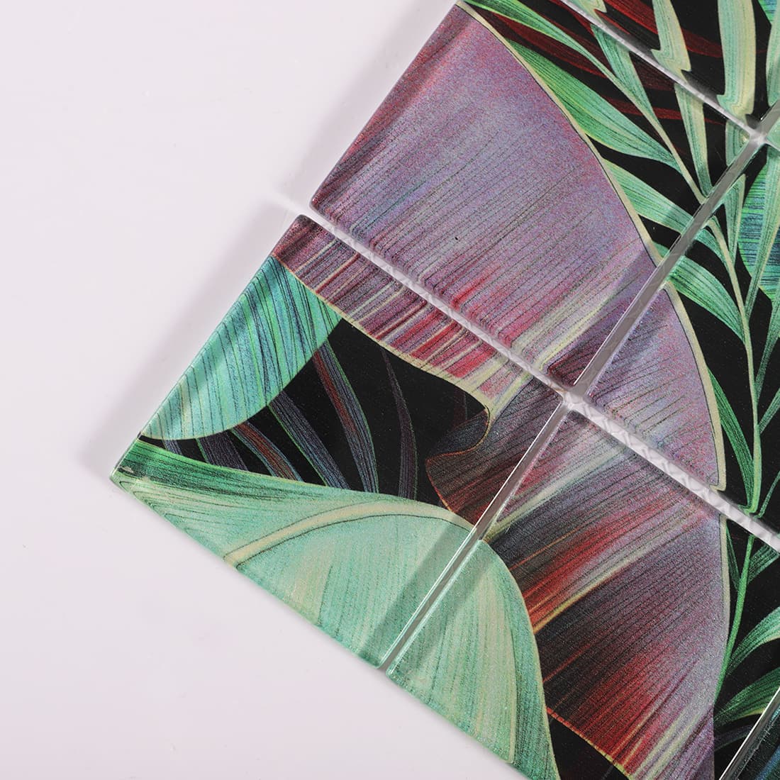 Corner detail of glossy green and burgundy tropical leaf glass mosaic tiles