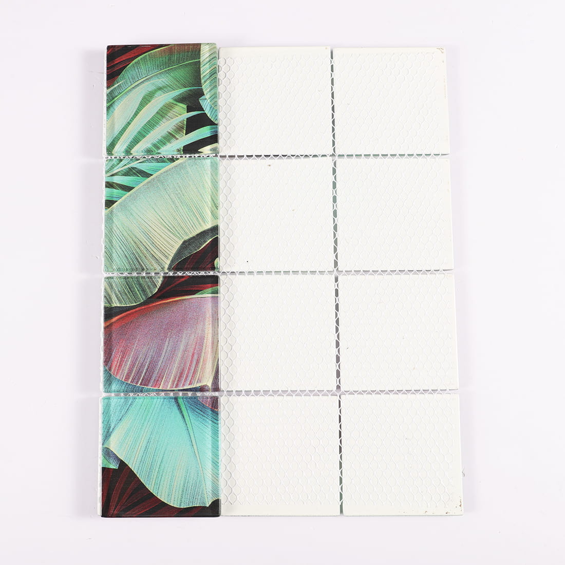 Mesh backing of tropical leaf patterned square glass mosaic tile sheet