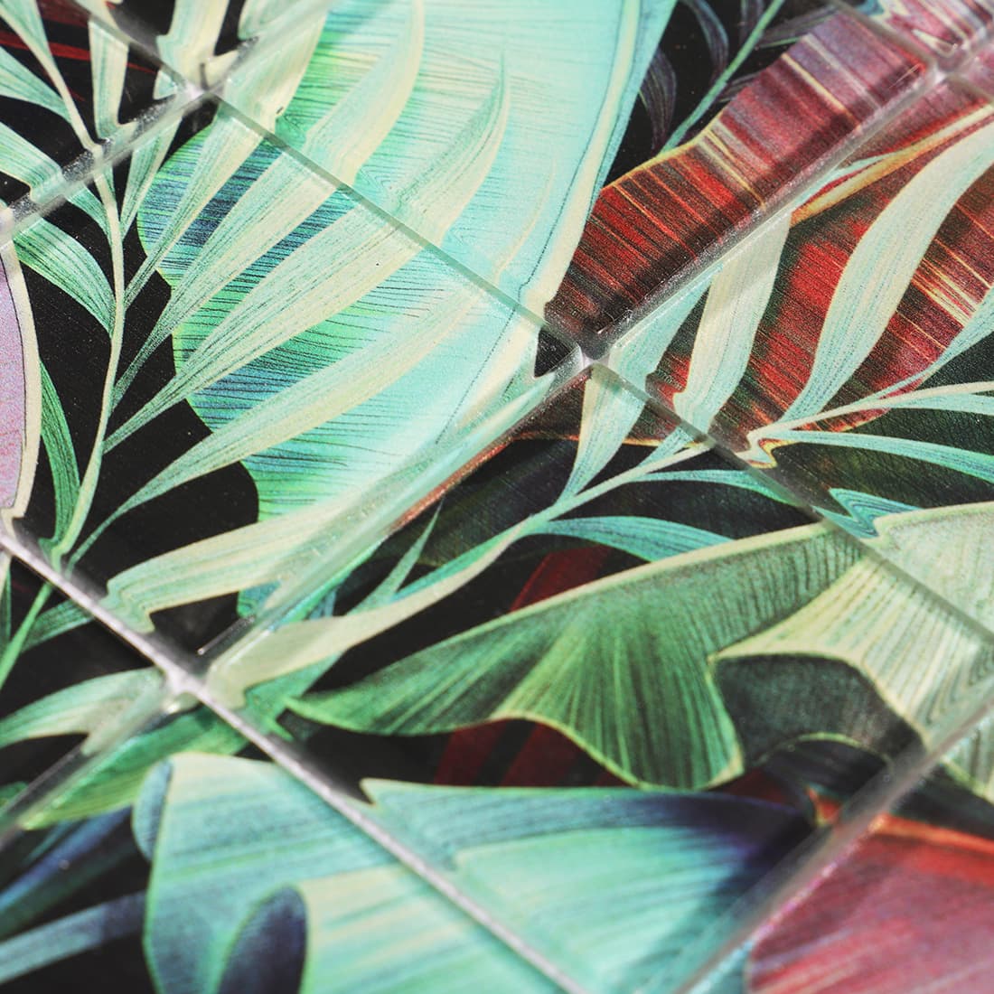 Close-up of glossy tropical leaf patterned glass mosaic tile surface