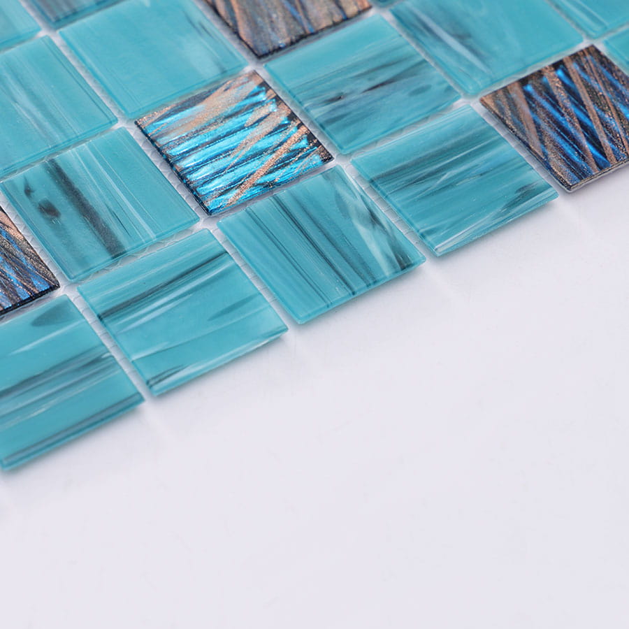 Angled view of turquoise mosaic tile sheet with metallic textured squares