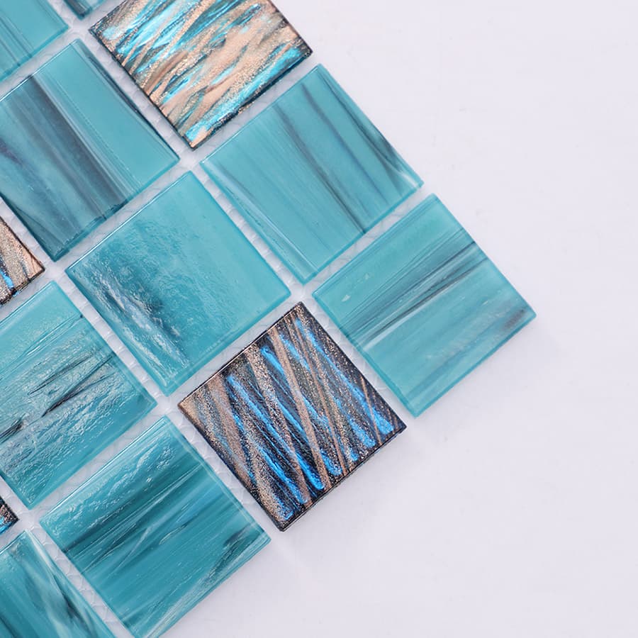 Close up of turquoise mosaic tile corner with metallic textured square