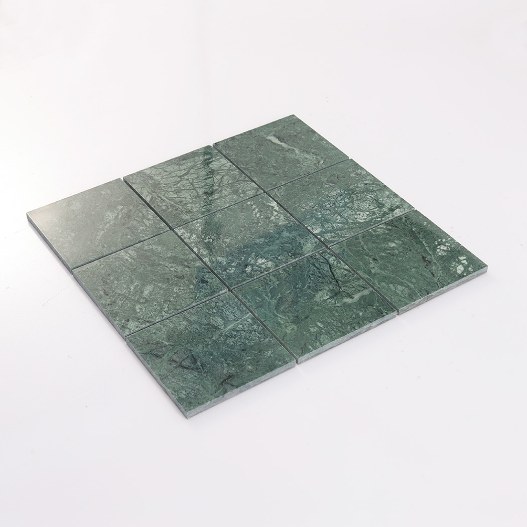 Angled display of verde green large square marble tile with clean joints