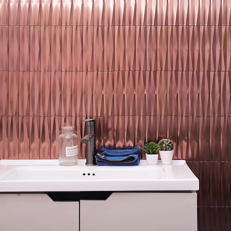 Vertical copper subway tiles with 3D texture on modern bathroom wall above white sink counter
