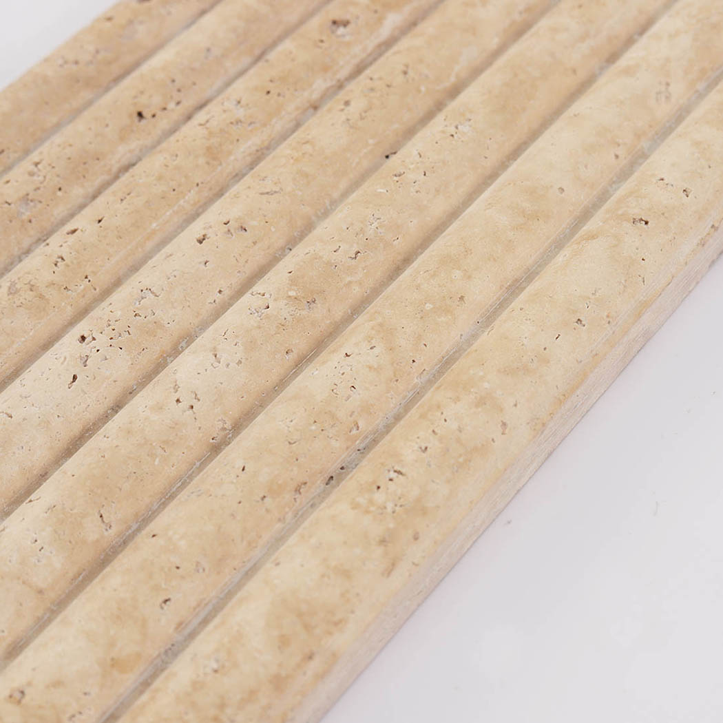 Detailed look at the parallel ridges and natural pits on a fluted travertine panel.