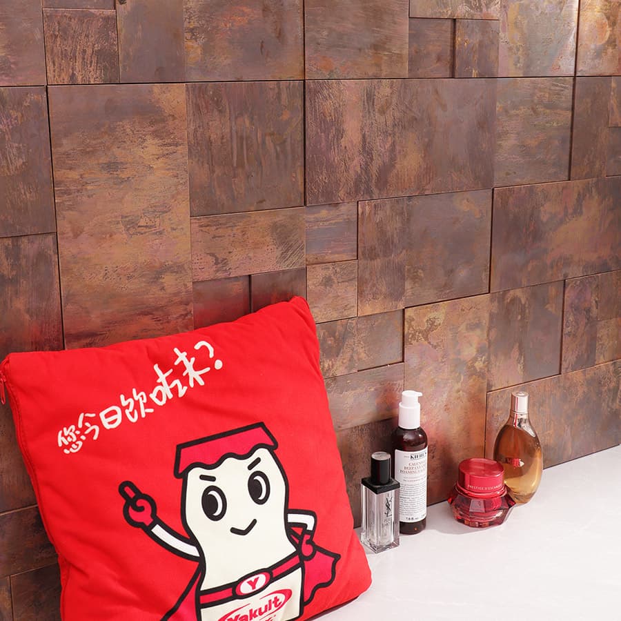 Vintage copper mosaic tile wall with red cushion and cosmetic items at side