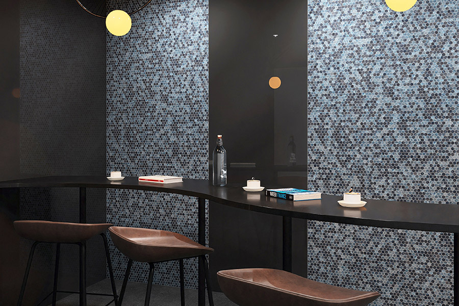 Detailed view of blue vitreous glass hexagon mosaic tiles with shimmering finishes.