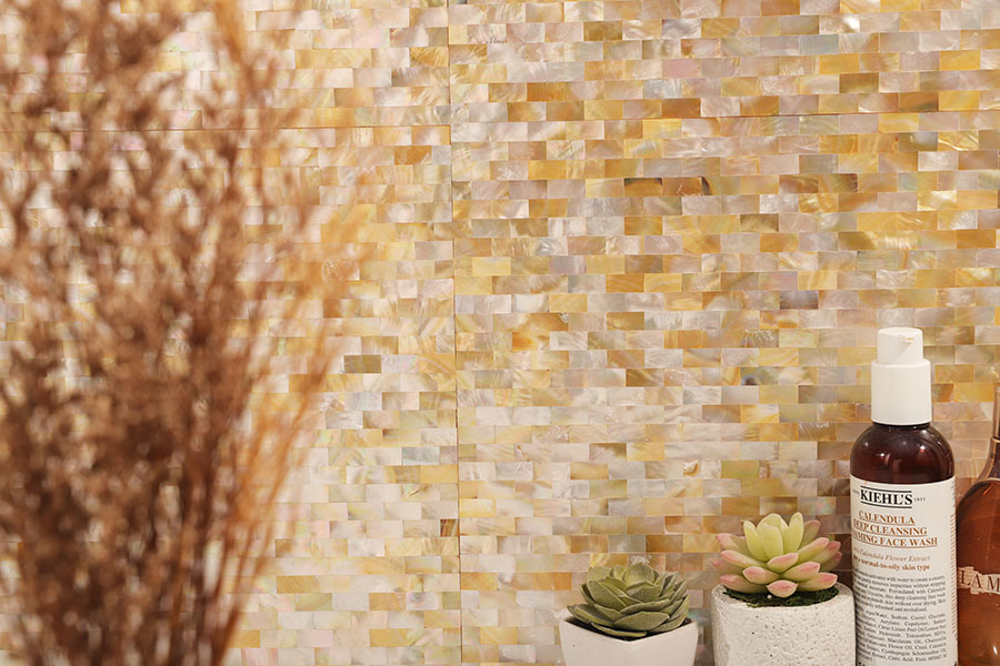 Warm mother of pearl subway mosaic tile backsplash with soft gold tones