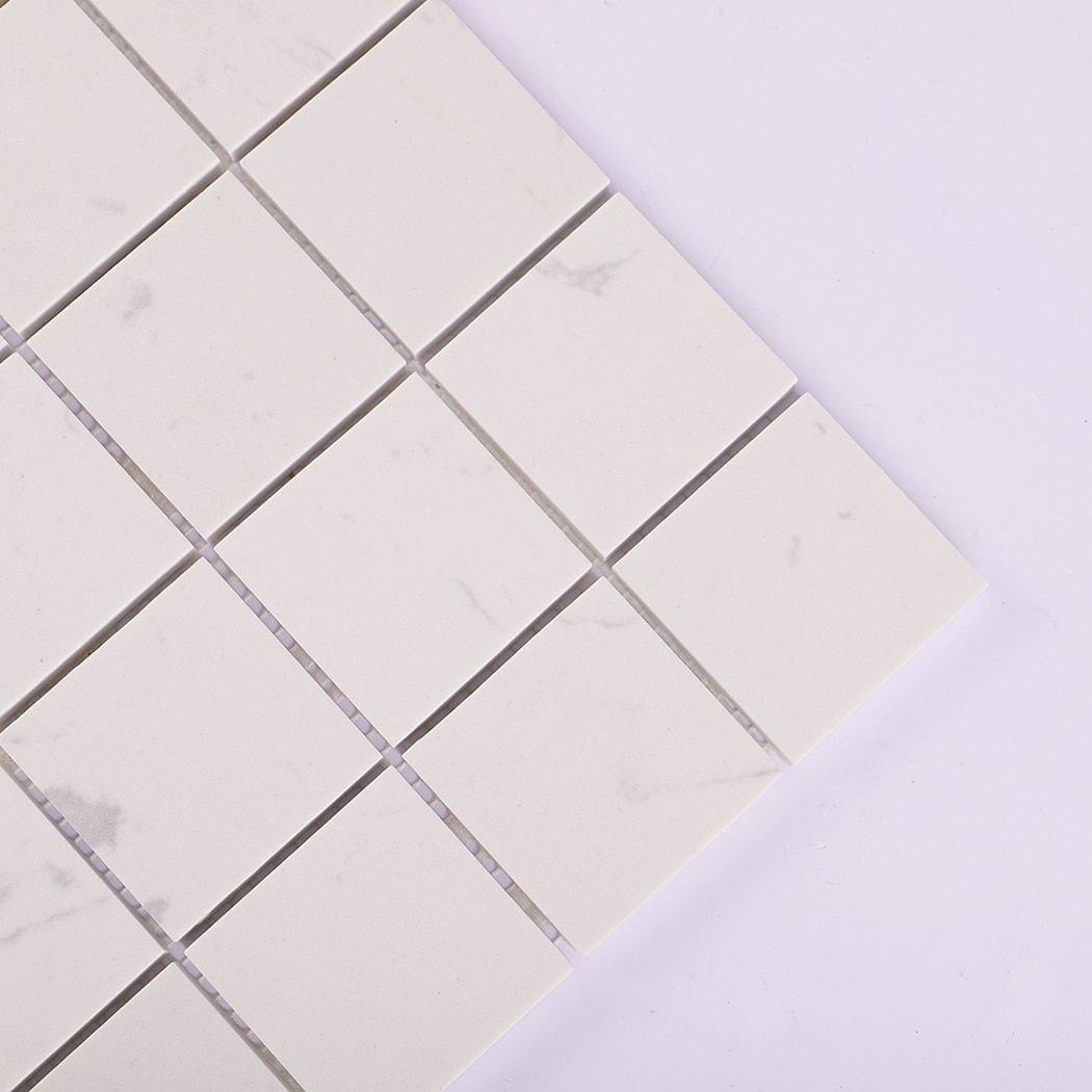Close-up of the corner section of white engineered marble mosaic tile squares.