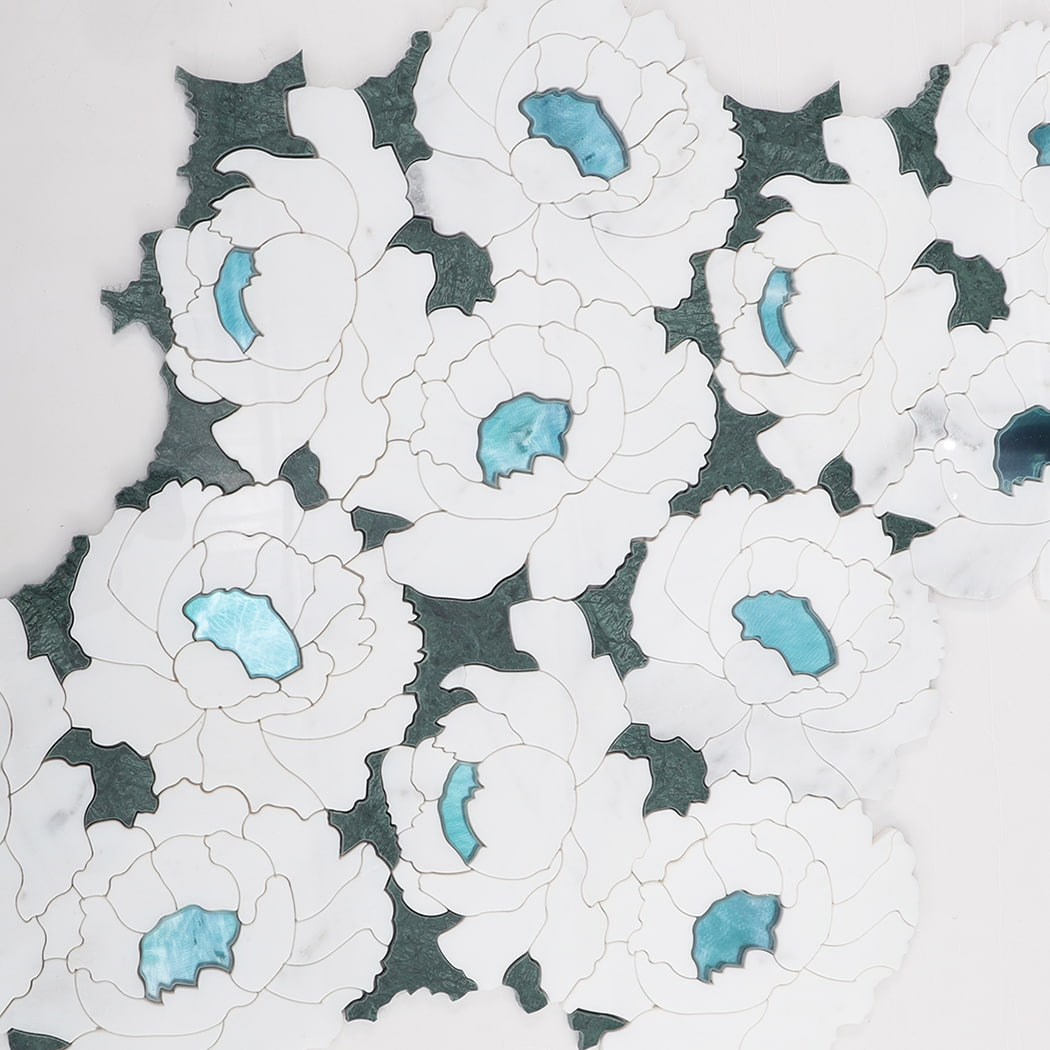 Layout display of white floral marble mosaic tiles with blue glass centers and green leaf details