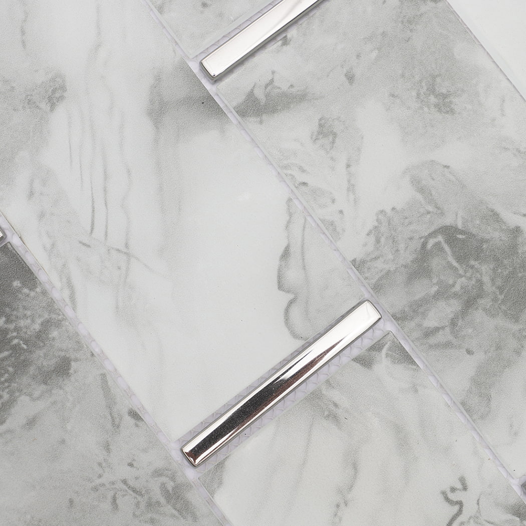 Close-up of white gray marble look glass subway mosaic tiles and silver accents
