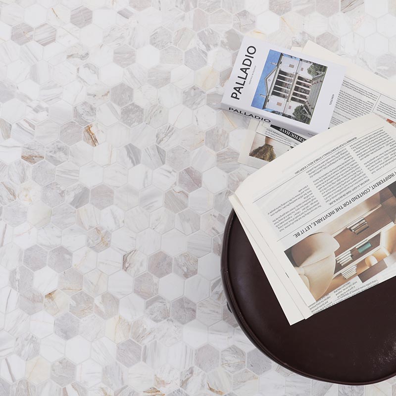 Mosaic floor tiles in white and gray hexagon marble beside a round table and magazines