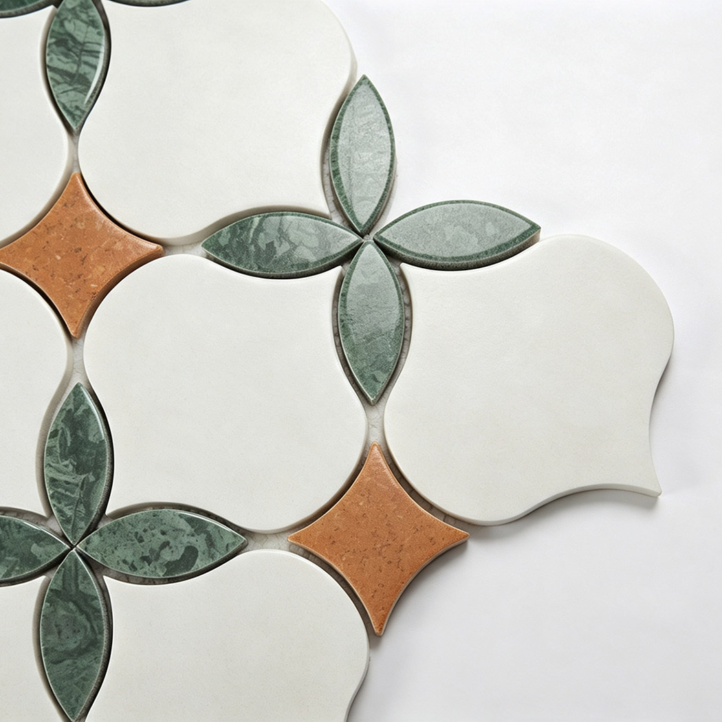 Close-up of white arabesque marble, green leaf petals, and orange stone mosaic accents