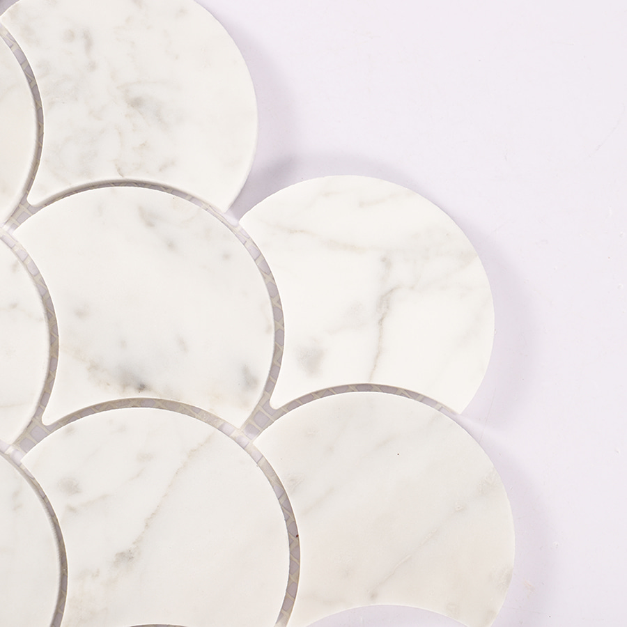 Corner close up of white marble fish scale mosaic tile showing smooth edges.