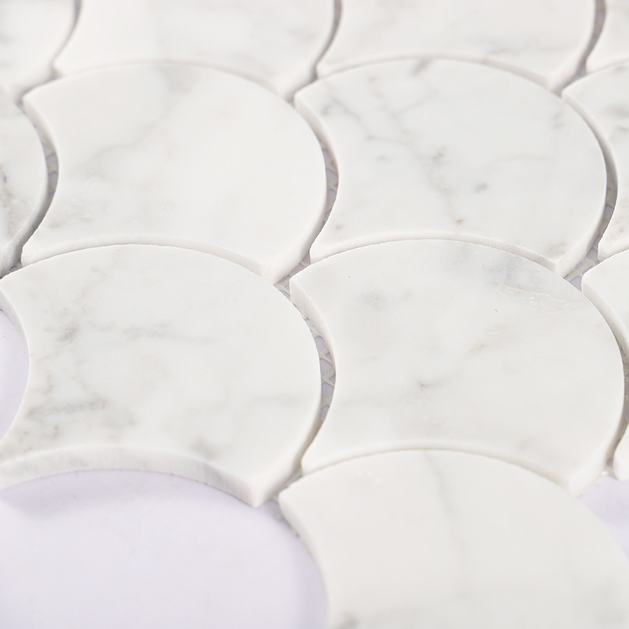 Side angle view showing texture and thickness of white marble fish scale mosaic tile.