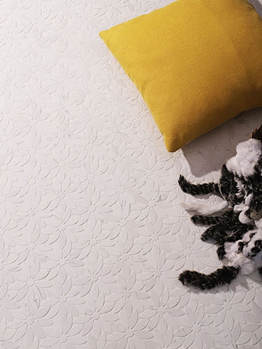 White floral marble floor tile paired with yellow pillow and fur blanket