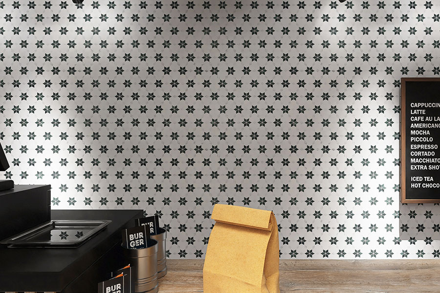 Wide view of white marble flower mosaic cafe wall with black counter and menu board