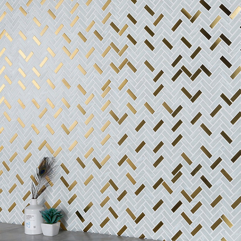 Close-up of white marble and gold metal herringbone mosaic tile wall with decorative vase 