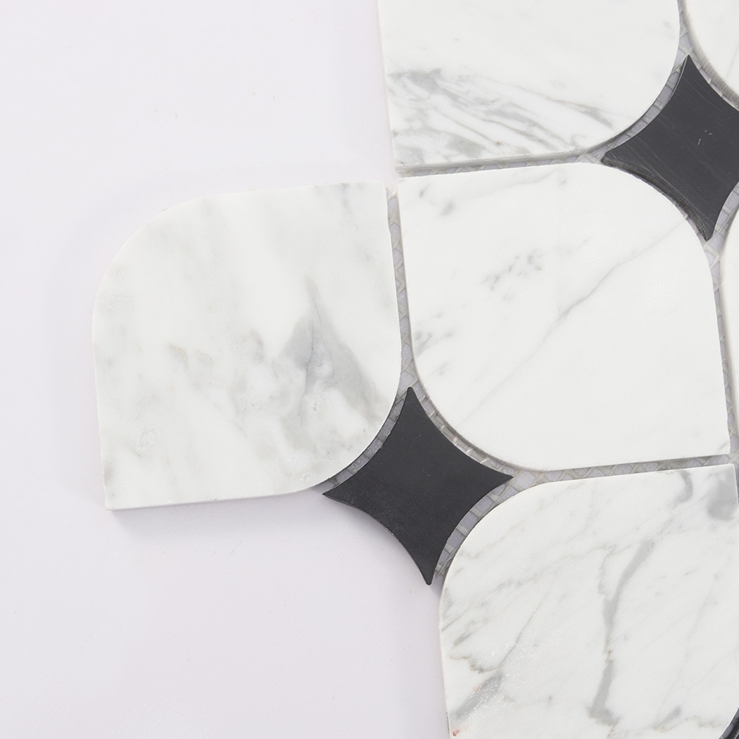 Corner close-up of white marble mosaic tile with black square insert