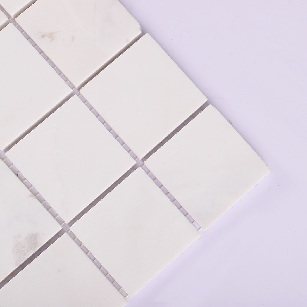 Close-up of the corner of white marble mosaic tile squares.