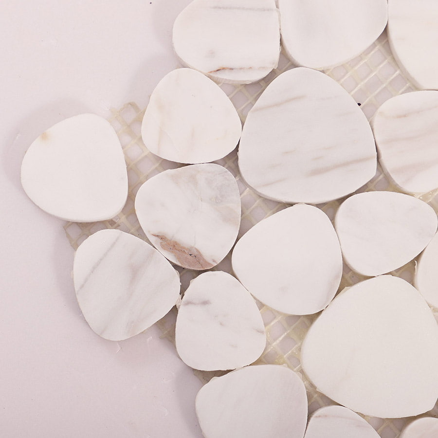 Corner close-up of white marble pebble mosaic tile on mesh