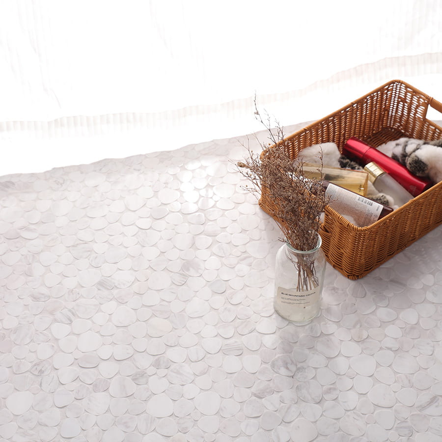 White marble pebble mosaic tiles with bathroom decor and basket