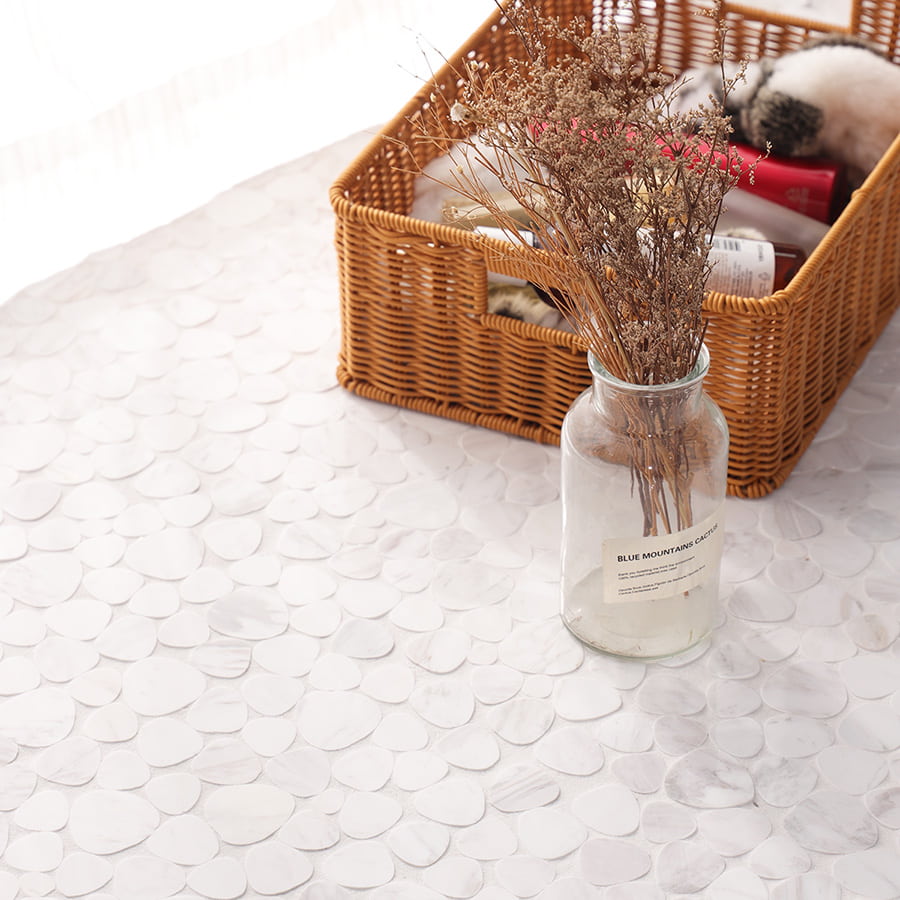 White marble pebble mosaic tiles styled with dried flowers and basket