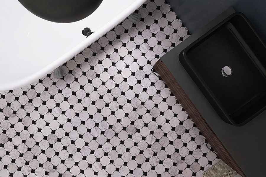 Top view of white marble bathroom floor tile with black quatrefoil pattern