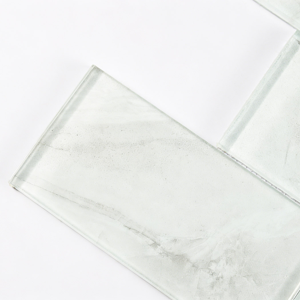 Angled close up view of glass tile with realistic white marble veining texture.