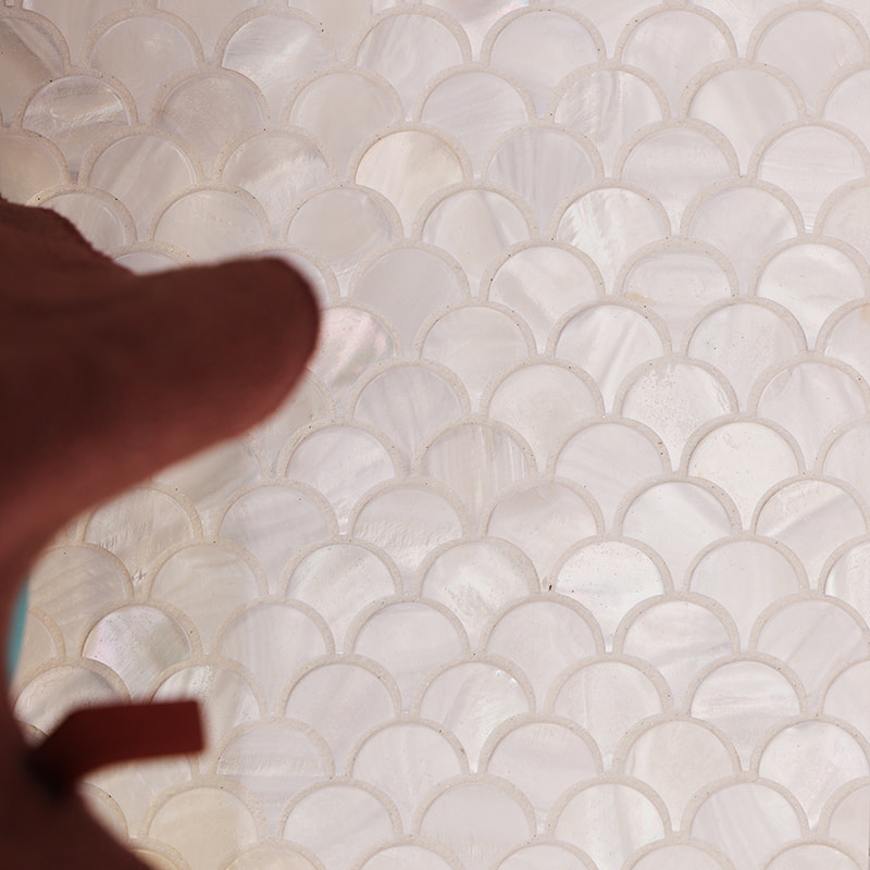 Close-up of white pearl fish scale mosaic tiles with iridescent shell texture