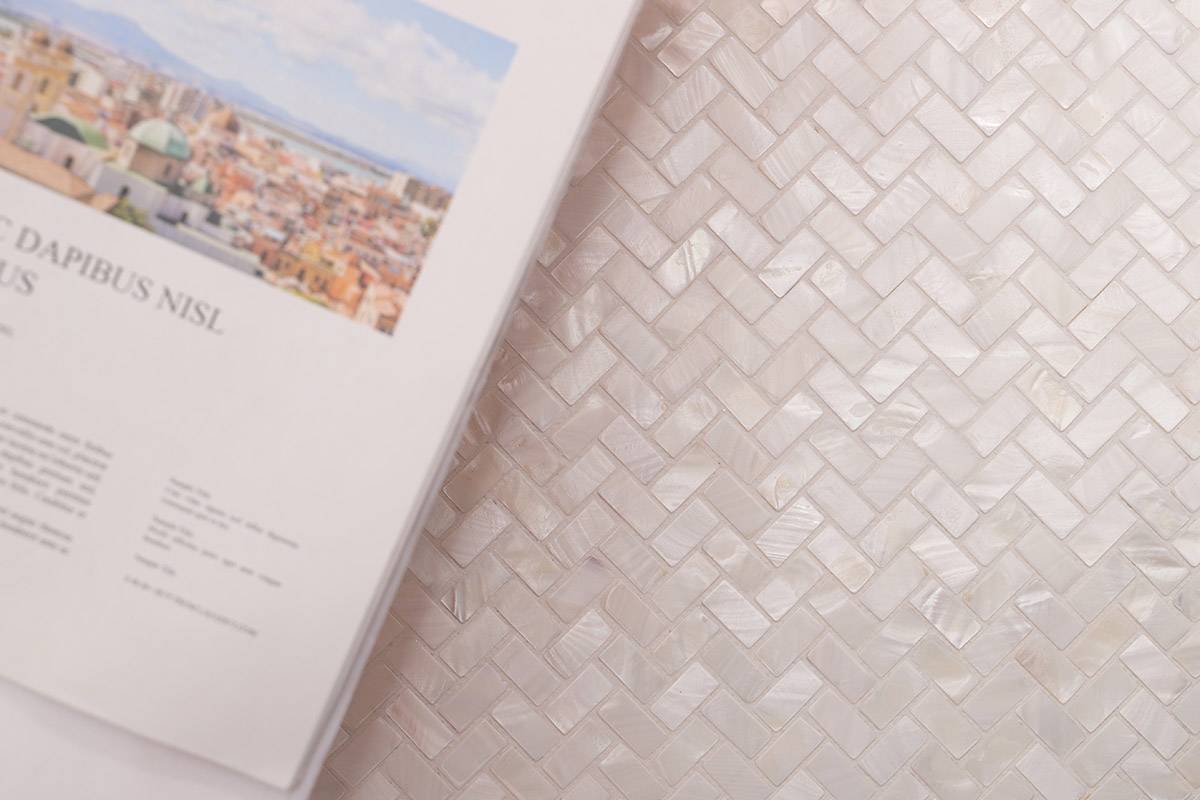 White pearl herringbone mosaic tile with a glossy iridescent finish