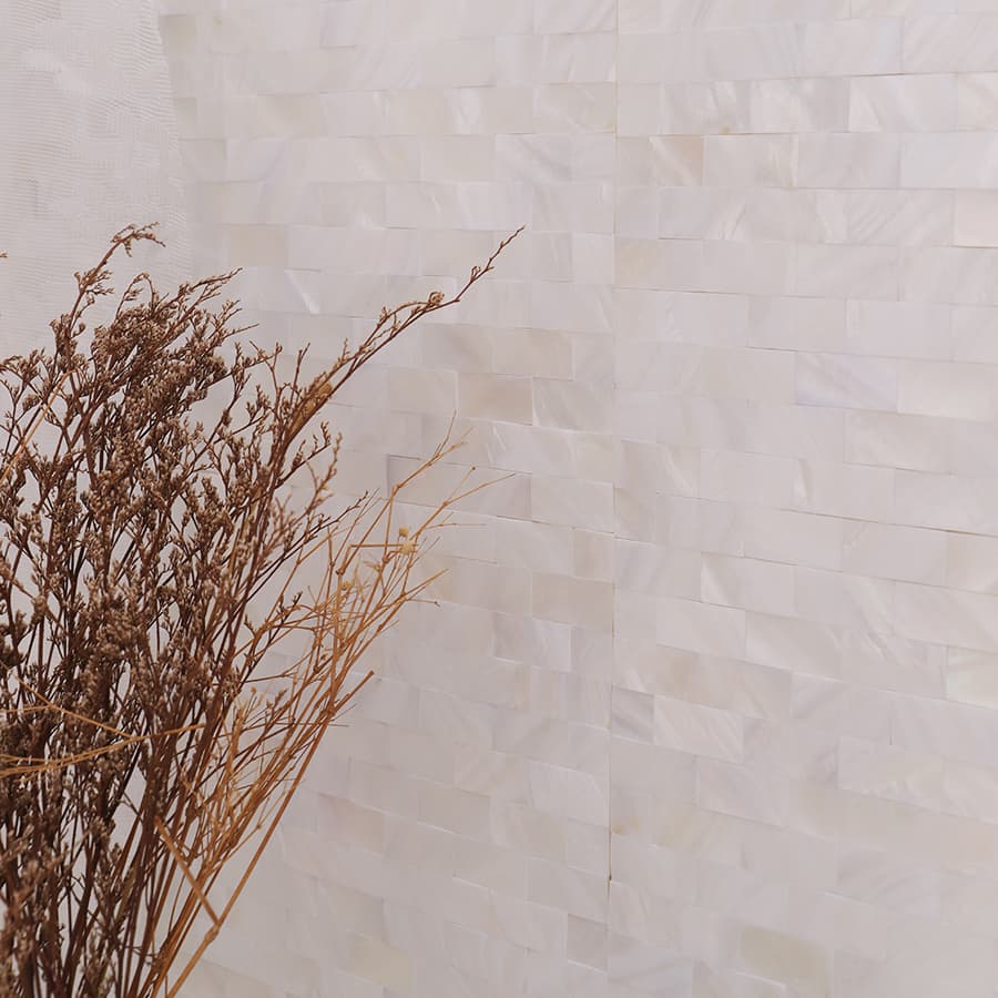 Close-up of white pearl strip mosaic wall with floral lace curtain