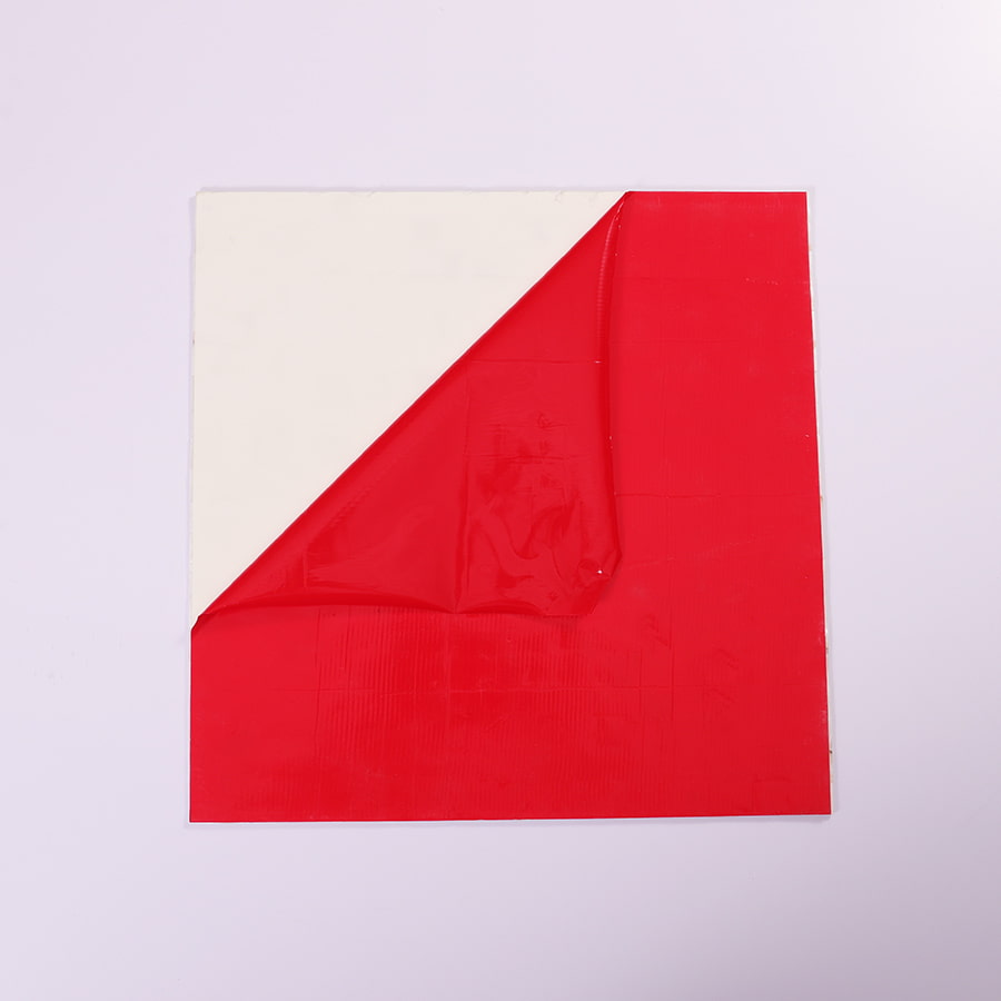 Backside of white shell mosaic tile with red protective film for self-adhesive installation