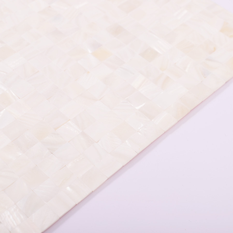 Angled edge view of white shell mosaic showing thickness and finish
