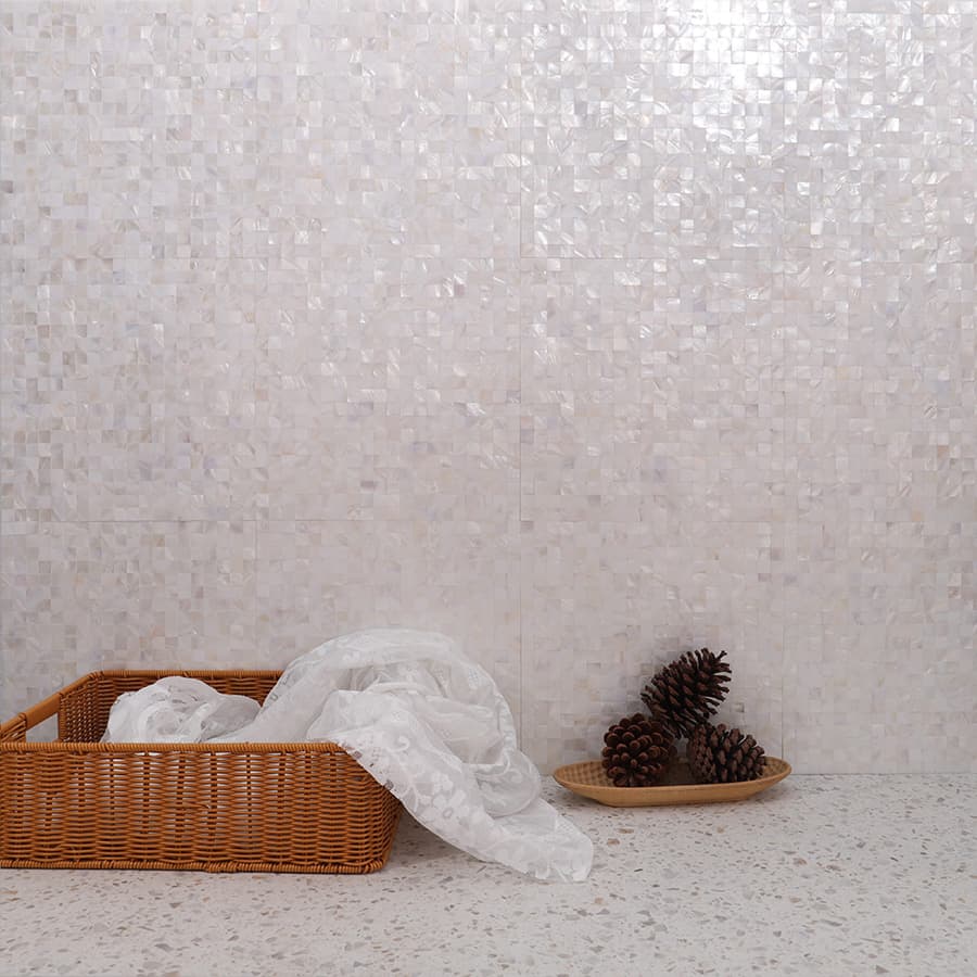 White shell mosaic tile wall with basket and pinecones